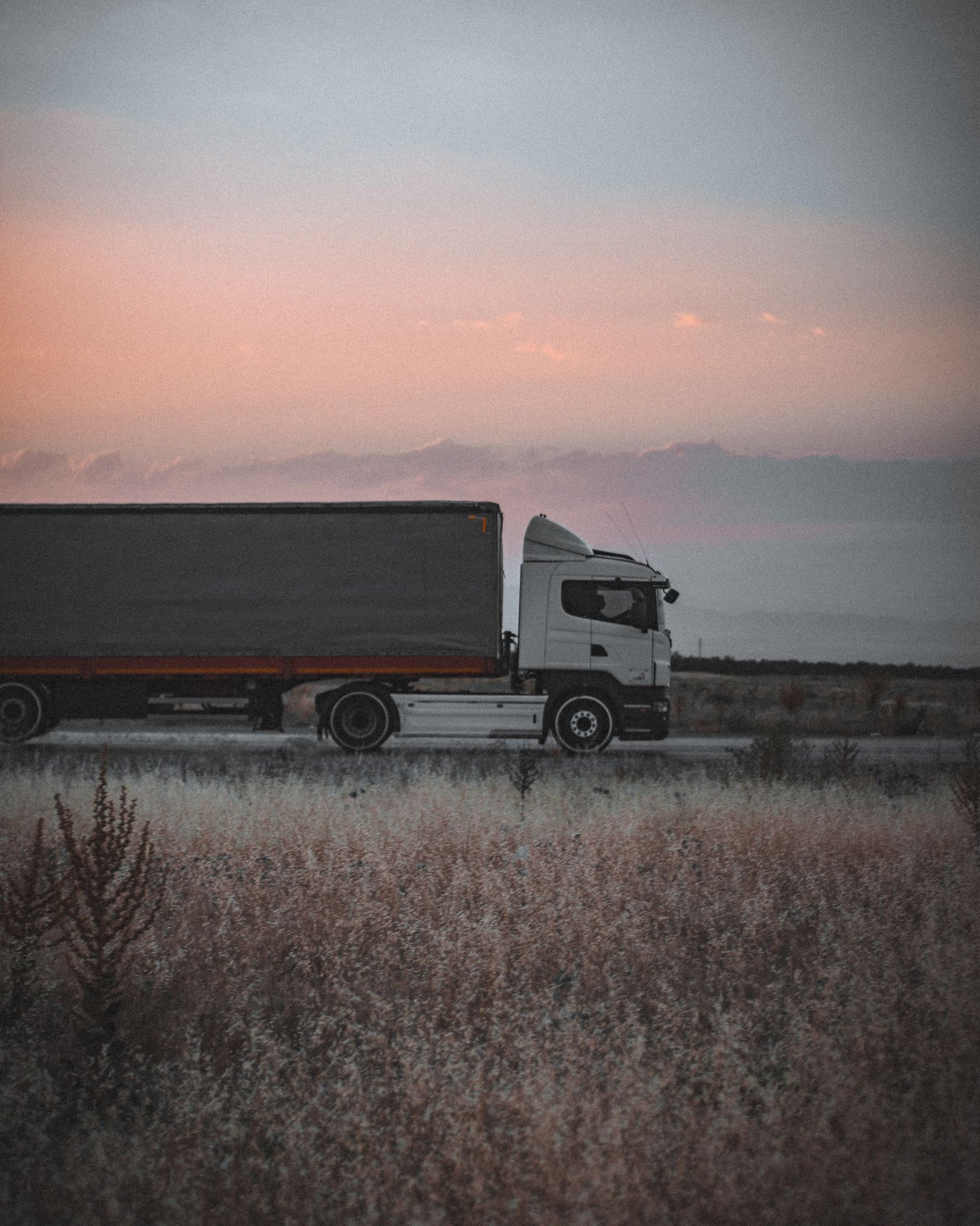 Freight truck moving through an open road landscape